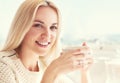 Pretty young woman with cup of coffee in sunny restaraunt