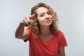 Pretty Young woman with curly hair looking at the camera and pointing her finger at you. Human emotions concept Royalty Free Stock Photo