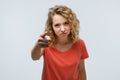 Pretty Young woman with curly hair looking at the camera and pointing her finger at you. Human emotions concept Royalty Free Stock Photo