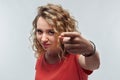 Pretty Young woman with curly hair looking at the camera and pointing her finger at you. Human emotions concept Royalty Free Stock Photo