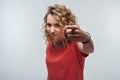 Pretty Young woman with curly hair looking at the camera and pointing her finger at you. Human emotions concept Royalty Free Stock Photo