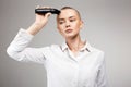Pretty young woman cutting her hair. bald Girl with hairclipper Royalty Free Stock Photo