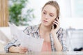 pretty young woman doing diy and talking on phone