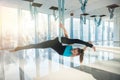 Pretty young woman doing fly yoga stretching exercises  in fitness training  gym. Health, fly yoga concept Royalty Free Stock Photo