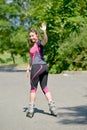 Pretty young woman doing rollerskate on a track