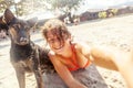 Pretty young woman doing selfie with her dog on the beach at sun Royalty Free Stock Photo