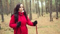 A pretty young woman is engaged in the nordic walking in woods. Royalty Free Stock Photo