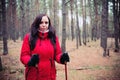 A pretty young woman is engaged in the nordic walking in woods. Royalty Free Stock Photo