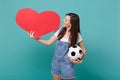 Pretty young woman football fan cheer up support favorite team with soccer ball, empty blank red heart isolated on blue Royalty Free Stock Photo