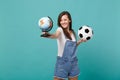 Pretty young woman football fan support favorite team with soccer ball, world globe isolated on blue turquoise