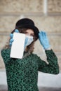 Pretty young woman in French style in medical mask and gloves show mobile phone Royalty Free Stock Photo
