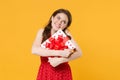 Pretty young woman girl in red summer dress posing isolated on yellow wall background studio portrait. Birthday holiday Royalty Free Stock Photo