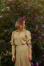 Pretty young woman in gold dress on buddleia field of wheat. Portrait of tender woman on a field Royalty Free Stock Photo