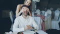 Pretty young woman is greeting her boyfriend in restaurant closing his eyes with her hands Royalty Free Stock Photo