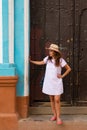 A pretty young woman with hat located at the door of an old colonial house in the colonial town of Trinidad Cuba Royalty Free Stock Photo