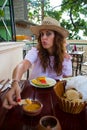 A pretty young woman with hat offering food towards the camera Royalty Free Stock Photo