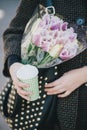 Pretty young woman in hat posing with coffee and flowers in bag Royalty Free Stock Photo