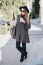 Pretty young woman in hat posing with coffee and flowers in bag Royalty Free Stock Photo