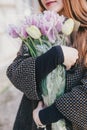 Pretty young woman in hat posing with flowers in bag Royalty Free Stock Photo