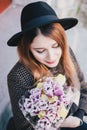 Pretty young woman in hat posing with flowers in bag Royalty Free Stock Photo