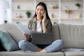 Pretty young woman having phone conversation, using laptop, holding documents Royalty Free Stock Photo