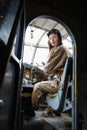 Pretty young woman in a helmet and pilot`s suit sits in the cockpit