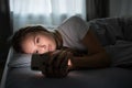 Pretty, young woman in her bed with her cell phone Royalty Free Stock Photo