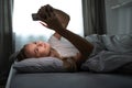 Pretty, young woman in her bed with her cell phone Royalty Free Stock Photo