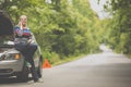 Pretty, young woman with her car broken down by the roadside Royalty Free Stock Photo