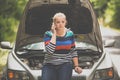 Pretty, young woman with her car broken down by the roadside Royalty Free Stock Photo