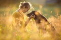 Pretty, Young Woman With Her Large Black Dog On A Lovely Sunlit Meadow