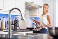 Pretty, young woman in her modern, clean and bright kitchen Royalty Free Stock Photo