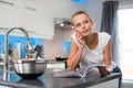 Pretty, young woman in her modern, clean and bright kitchen Royalty Free Stock Photo