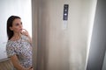 Pretty, young woman in her modern kitchen, by the fridge Royalty Free Stock Photo