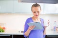 Pretty, young woman with her morning coffee and a tablet Royalty Free Stock Photo