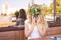 Pretty young woman hide face by green. Outdoors anonymity portrait