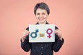 Pretty young woman hipster holding a white paper sheet with message for gender equality concept as male and female symbol are