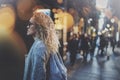 Pretty young woman hipster in stylish clothing wearing eye glasses traveling in the european night city. Bokeh and