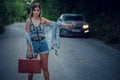 Pretty young woman hitchhiking along a road Royalty Free Stock Photo