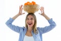 Pretty young woman holding a bowl over her head with oranges over white background Royalty Free Stock Photo