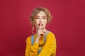 Pretty young woman holding finger near lips, silent gesture Royalty Free Stock Photo