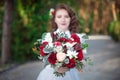 Pretty young woman holding flower bouquet in white shirt outdoor Royalty Free Stock Photo