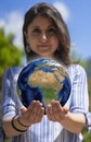 Pretty young woman holding globe on her hands. Environment conservation and energy saving. Ecology and save the planet concept Royalty Free Stock Photo