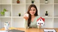 Pretty young woman holding house models and smiling at camera. Real estate, mortgage loan and home insurance concept Royalty Free Stock Photo