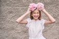 Pretty young woman holding peony bloom like wreath