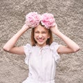 Pretty young woman holding peony bloom like wreath