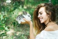 Pretty young woman holds rabbit