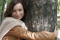 Pretty young woman hugging tree in a park Royalty Free Stock Photo