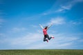 Pretty young woman jumping on green grass Royalty Free Stock Photo