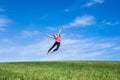 Pretty young woman jumping on green grass Royalty Free Stock Photo